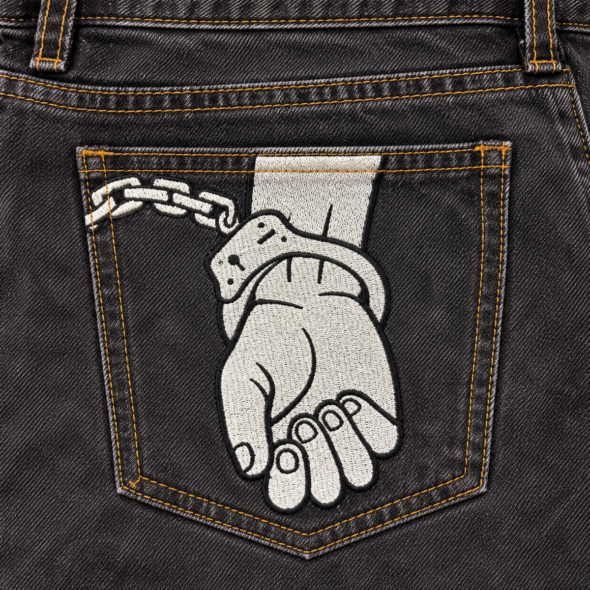 CROOKSLDN Grey Wash Yard Jeans — solid white cuffed-hand rear pocket embroidery with black outlines and gold topstitching.