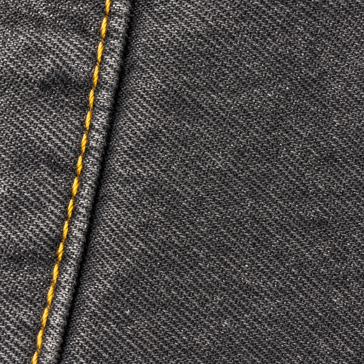 CROOKSLDN Grey Wash Yard Jeans — charcoal-black denim wash, fine weave and gold seam stitching macro.
